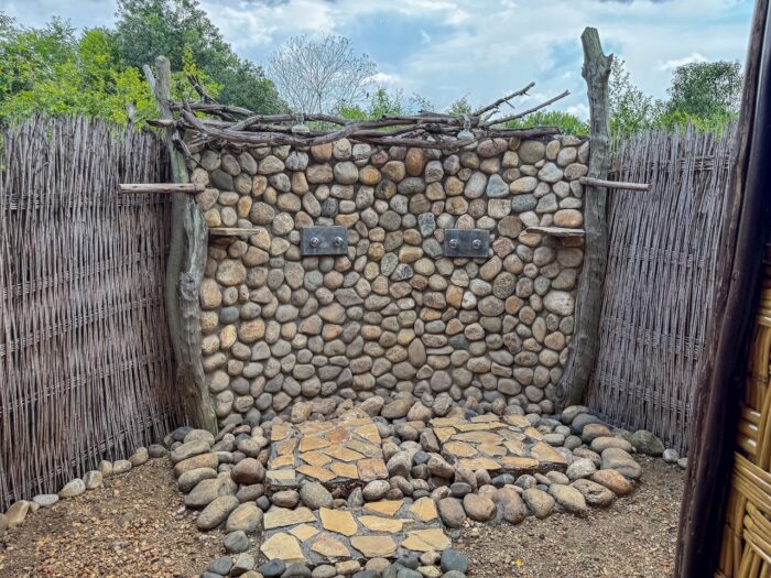 Outdoor shower with stone wall and natural elements in Uganda.