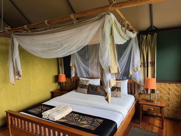 Uganda bedroom with four-poster bed, mosquito net, and African-inspired decor.