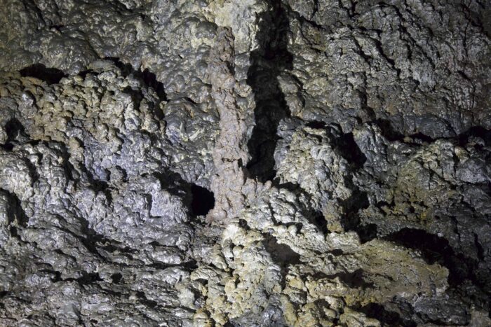 Textured rock formation in Iceland cave, likely lava rock.