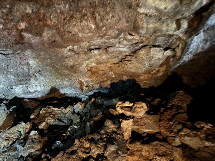Lava cave interior with rough rock formations and shadows in Iceland.