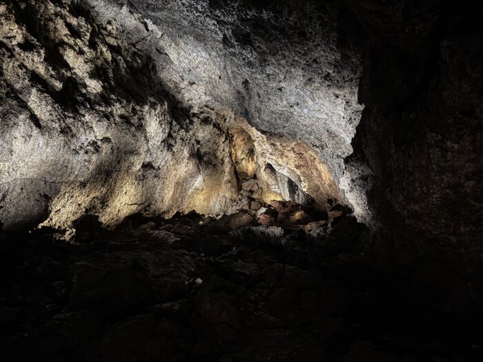 Lava cave interior with dramatic lighting in Iceland. Rock formations and dark shadows.