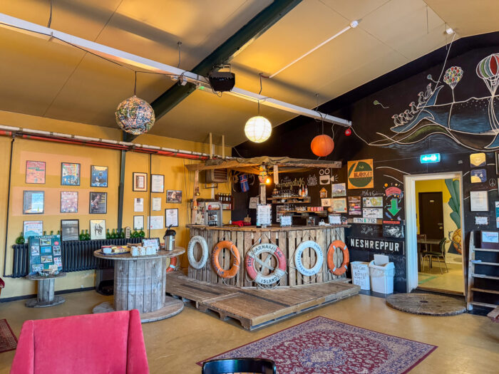 Cozy cafe interior with bar, life preservers, and colorful decor.