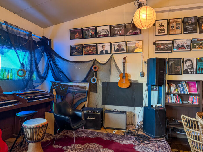 Music room with instruments, vinyl records, and amplifiers, featuring a djembe drum.